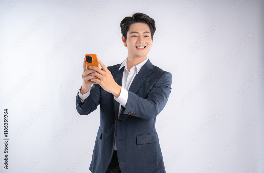 Portrait of young Asian business man using phone and posing on white background Portrait of young Asian business man using phone and posing on white background
