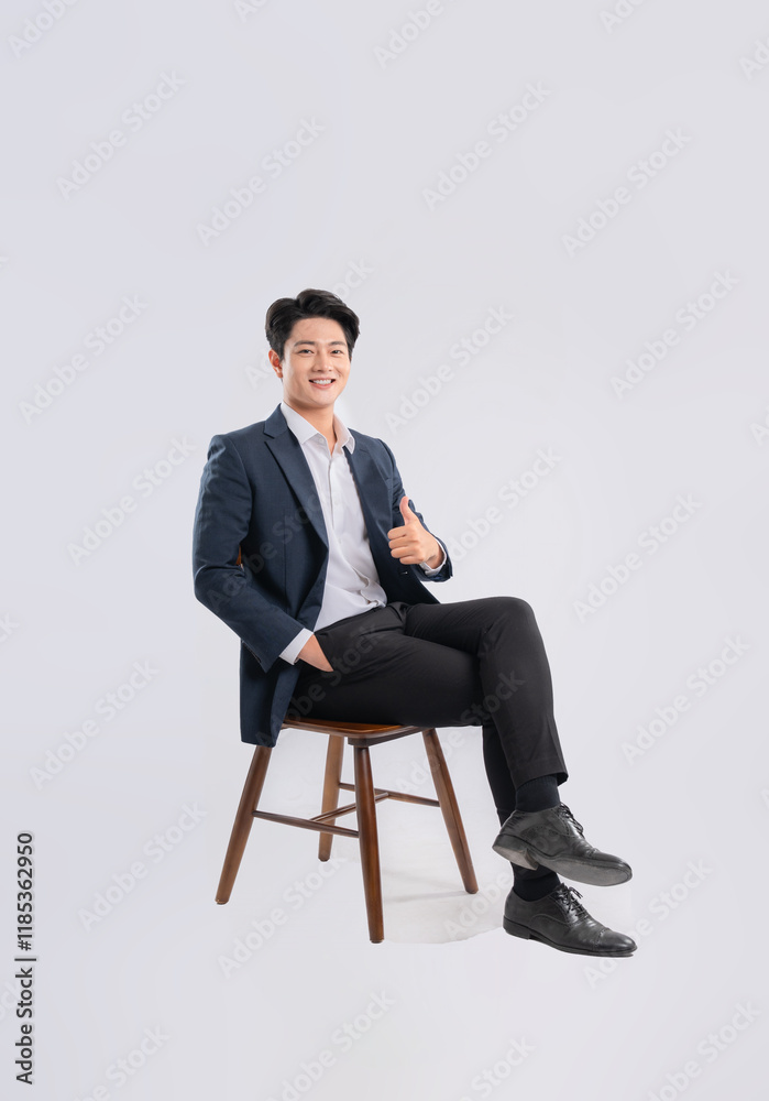 Full body image of young Asian business man sitting in chair on white background Full body image of young Asian business man sitting in chair on white background
