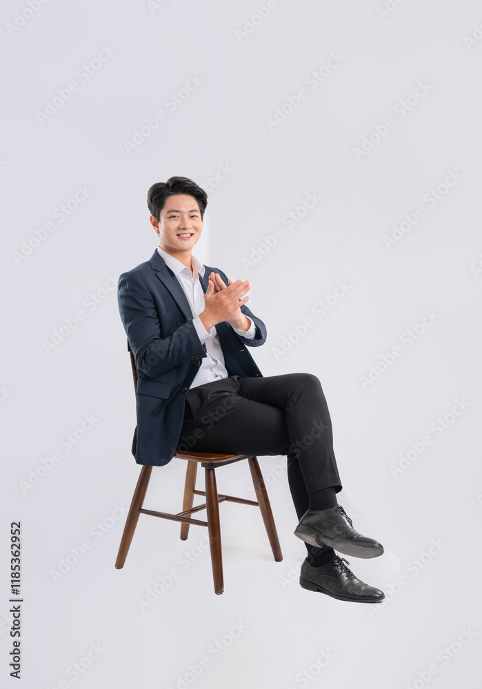 Full body image of young Asian business man sitting in chair on white background Full body image of young Asian business man sitting in chair on white background