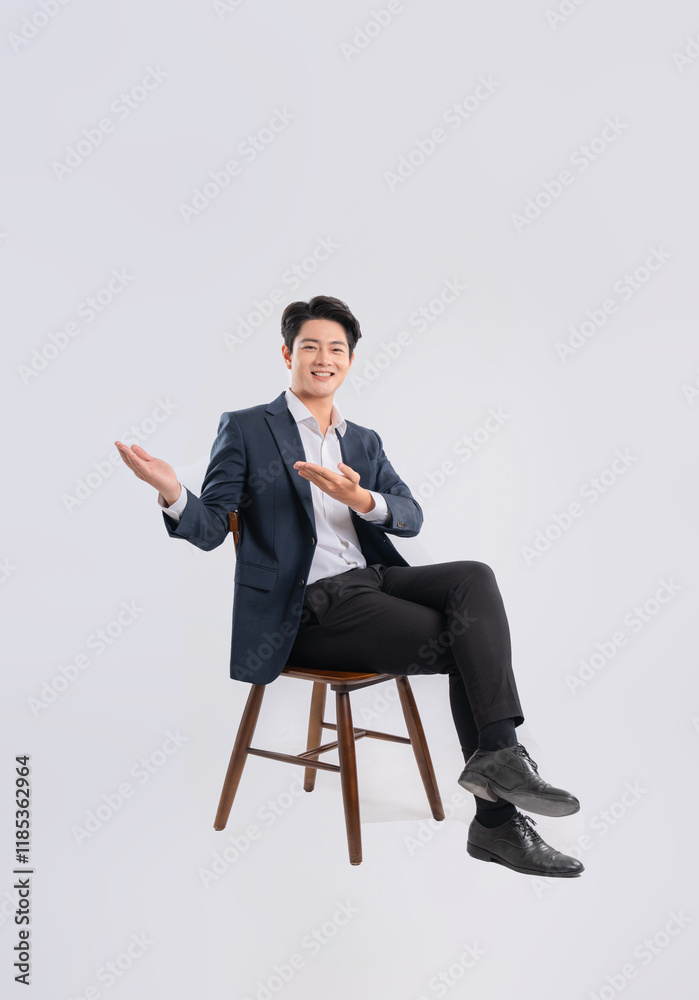 Full body image of young Asian business man sitting in chair on white background Full body image of young Asian business man sitting in chair on white background