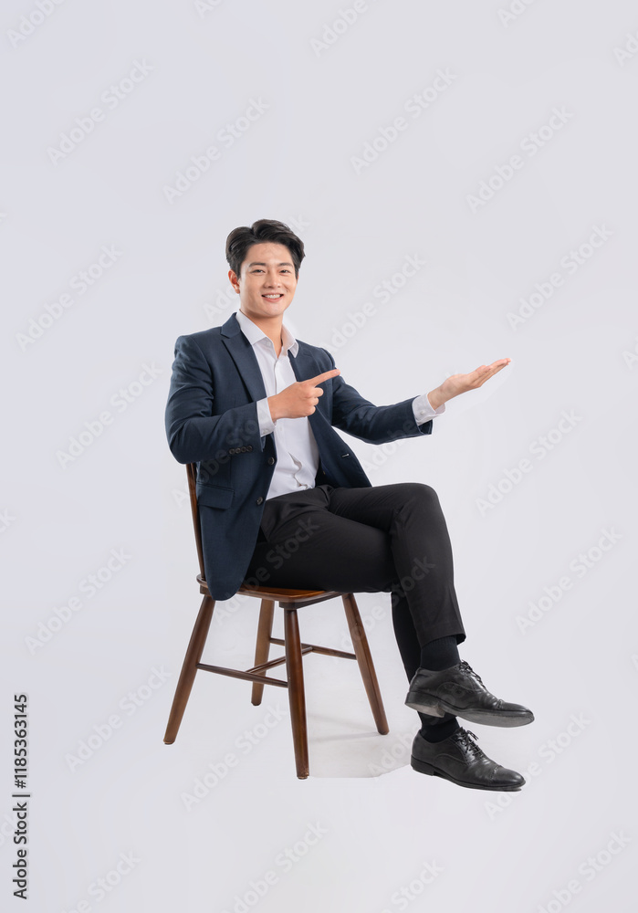 Full body image of young Asian business man sitting in chair on white background Full body image of young Asian business man sitting in chair on white background