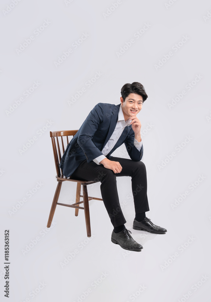Full body image of young Asian business man sitting in chair on white background Full body image of young Asian business man sitting in chair on white background