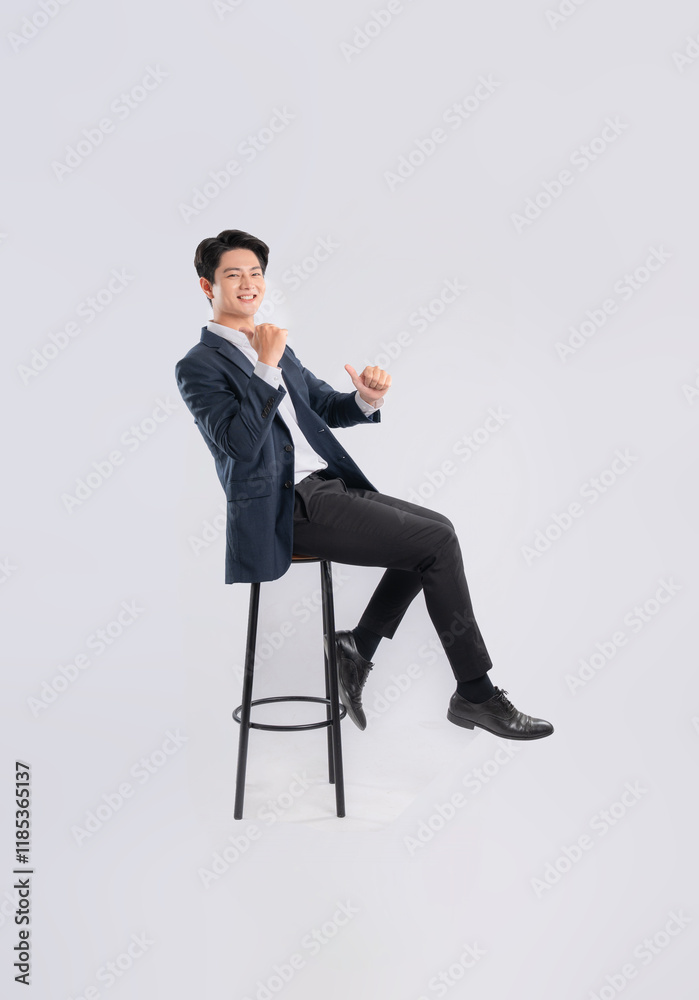 Full body image of young Asian business man sitting in chair on white background Full body image of young Asian business man sitting in chair on white background