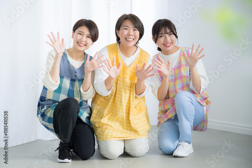 保育士や幼稚園の先生のイメージ　バイバイと手を振る、こんにちはなどのカメラ目線の笑顔