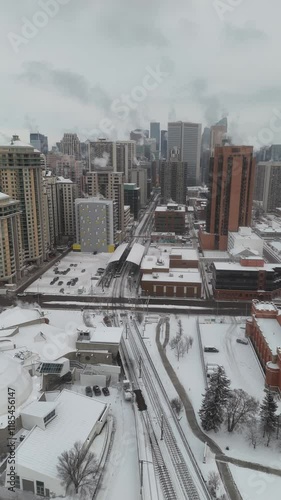 Vertical tracking shot city buildings with heat vapours rising from apartment buildings overlooking train tracks.
 photo