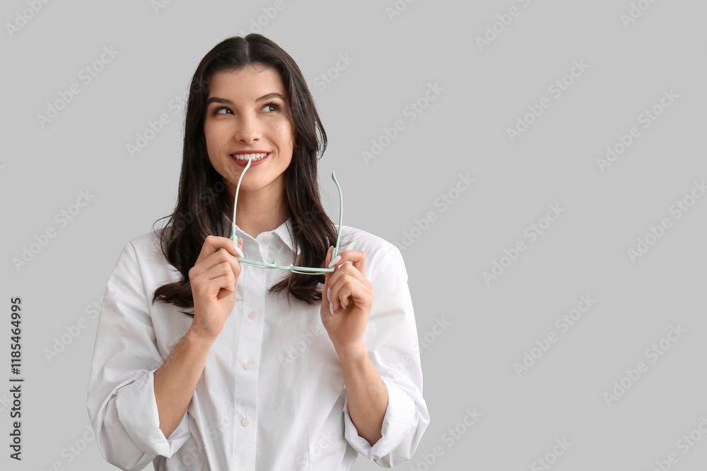 Happy smiling young woman holding eyeglasses on white background Happy smiling young woman holding eyeglasses on white background