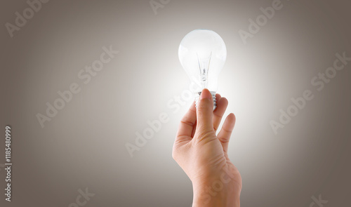 Hand holding energy saving lightbulb in the concept of energy in nature photo