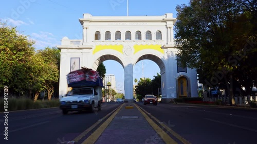 Guadalajara, Jalisco, México - Jan 8 2025: Timelapse, cars pass by. Majestic neoclassical arches built in 1942 in commemoration of the 400th anniversary of Guadalajara.