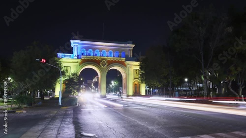 Guadalajara, Jalisco, México - Jan 8 2025: Night timelapse, , cars pass by. Majestic neoclassical arches built in 1942 in commemoration of the 400th anniversary of Guadalajara.
