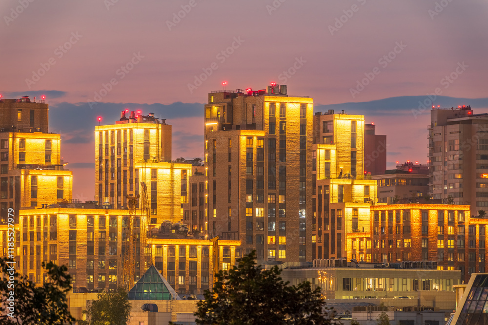 Obraz premium Night colorful windows lights of the high-rise residential building in city sleeping area