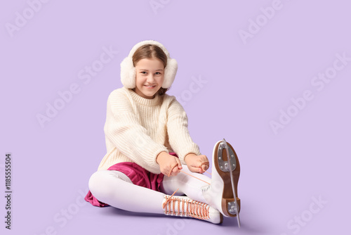 Cute girl in ice skates sit...