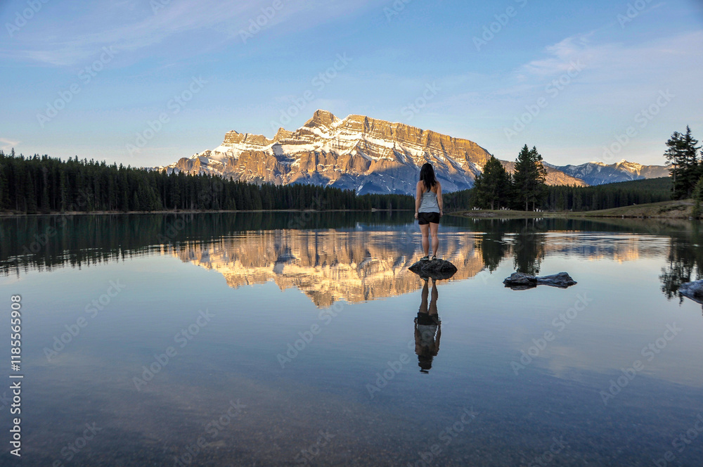 Fototapeta premium Stood on a rock at Two Jack Lake in Banff National Park watching the sunrise illuminate Rundle Mountain 