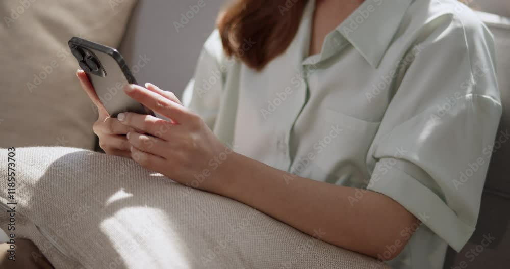 A person engages with their smartphone highlighting modern communication in a cozy setting. A person engages with their smartphone highlighting modern communication in a cozy setting.