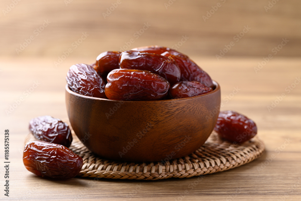 Date palm fruit (MedJool) in wooden bowl Date palm fruit (MedJool) in wooden bowl