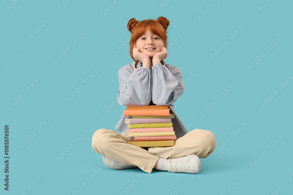 Teenage redhead girl with stack of books sitting on blue background Teenage redhead girl with stack of books sitting on blue background