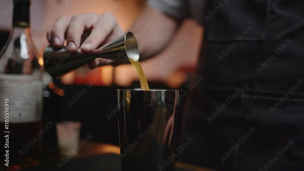 Craft cocktail pouring from jigger to shaker in cozy home bar. Perfect for bartender tutorials or cocktail recipe videos. Craft cocktail pouring from jigger to shaker in cozy home bar. Perfect for bartender tutorials or cocktail recipe videos.