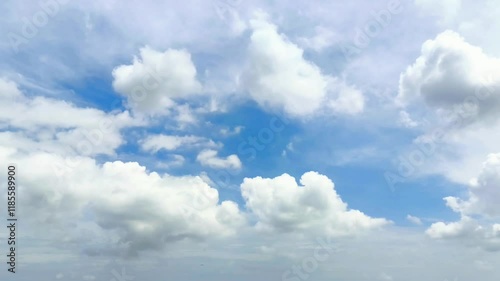 Bright white clouds fly across the bright blue sky. The sky is clear in the afternoon. Background view of clouds moving in the wind. Copy space