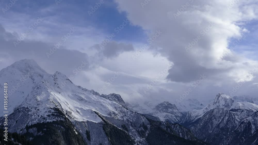 Hyperlapse of a breathtaking footage of the winter stormy clouds over snowy mountain peaks