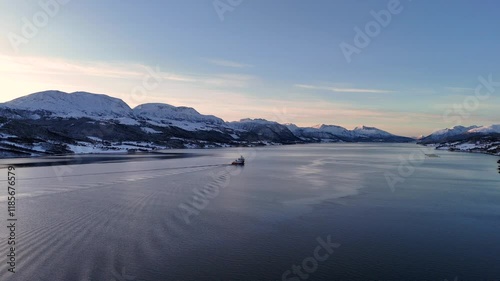 Aerial footage of a MOWI cargo vessel transiting the Kvernes fjord at sunset, Norway photo