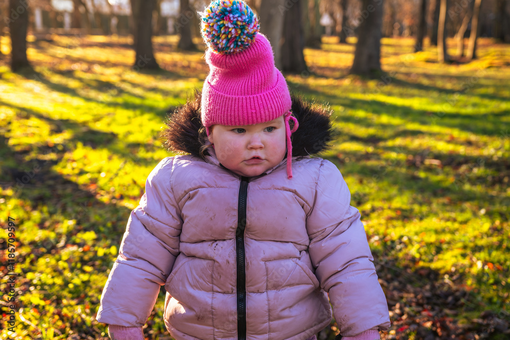 Child Enjoying a Sunny Day in a Park Wearing a Pink Hat and a Cozy Jacket Child Enjoying a Sunny Day in a Park Wearing a Pink Hat and a Cozy Jacket