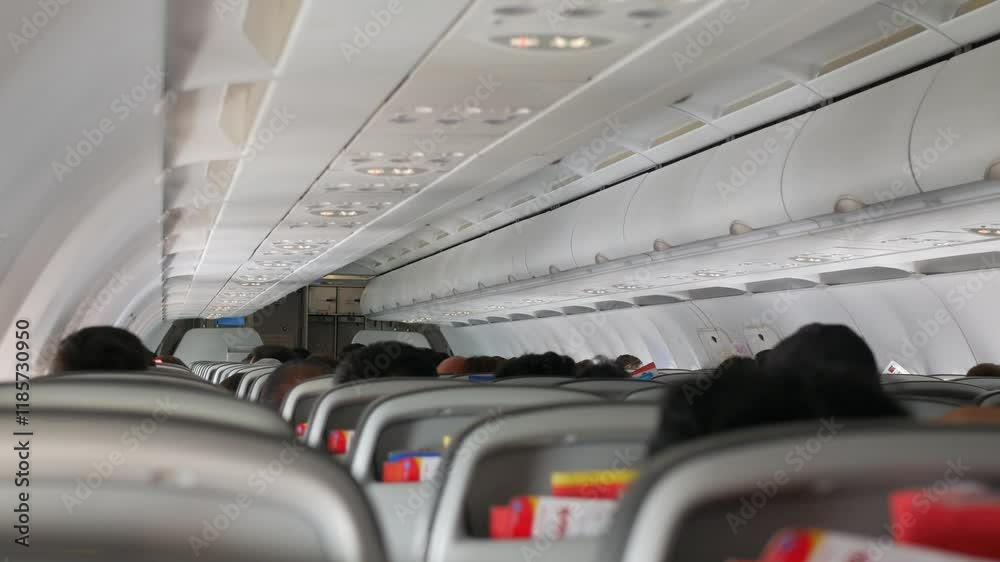 rear view of plane passenger seat inside aeroplane with selective focusing on seat while flying traveling