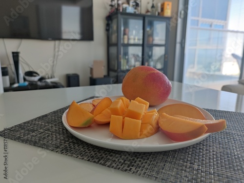 mango fruit. ripe mango fruit on a white plate. sliced ​​mango in the kitchen