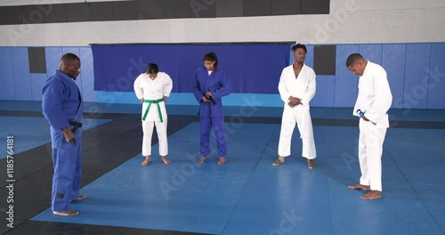 Practicing judo, group of athletes in martial arts uniforms on mat