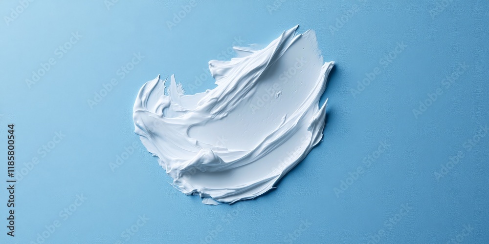 Creamy texture of cosmetic cream on a blue backdrop. The smear of face cream highlights the creamy base. Close up view of this creamy texture creates an appealing visual. Creamy texture of cosmetic cream on a blue backdrop. The smear of face cream highlights the creamy base. Close up view of this creamy texture creates an appealing visual.