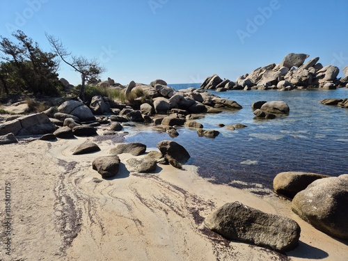 Plage de Tamaricciu, Breathtaking coastal scene featuring clear turquoise water, rocky outcrops, and white sandy shores in Porto Vecchio, South Corsica.