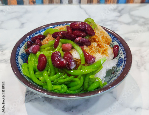 Cendol is a Malaysian dessert made of shaved ice, coconut milk, green pandan jelly noodles, and sweet dark brown sugar syrup. 
