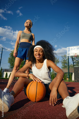 Obraz na płótnie Two attractive multicultural female basketball player taking rest w salonie