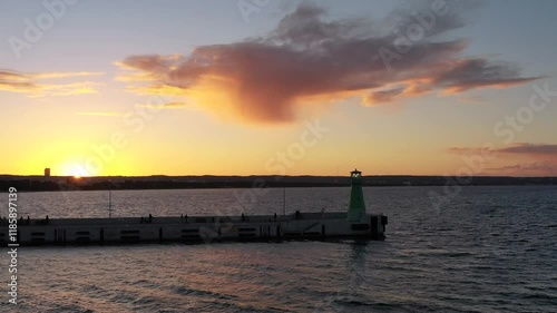 Green lighthouse on the western breakwater in Nowy Port at sunset, Gdansk.