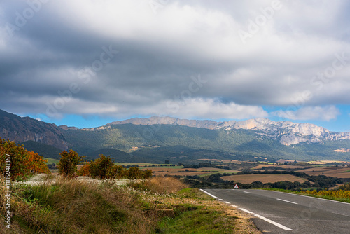 A captivating view showcasing a winding road leading into majestic mountains under an overcast sky, perfect for nature lovers and adventure seekers alike in a serene setting in Navarra Spain photo