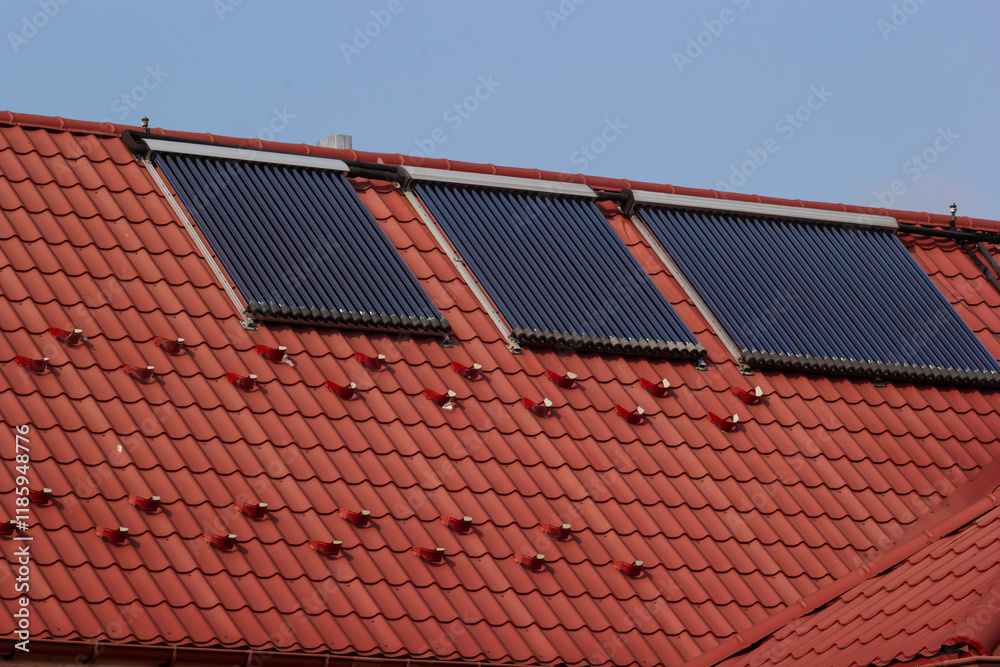 Solar panels on a red tiled roof harnessing renewable energy during daylight in a suburban area Solar panels on a red tiled roof harnessing renewable energy during daylight in a suburban area