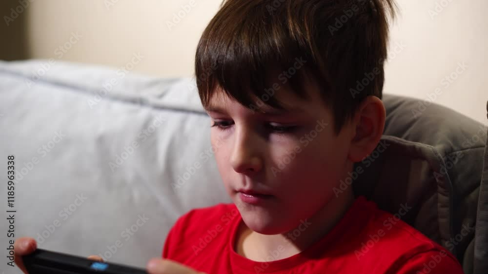 ten year old boy playing smartphone sitting on sofa ten year old boy playing smartphone sitting on sofa