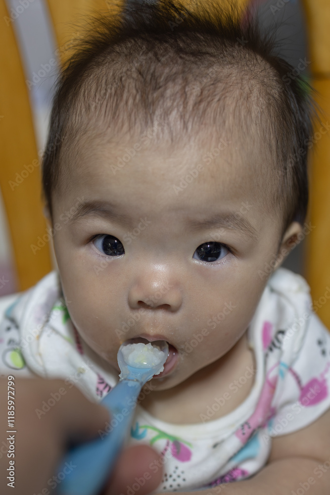 Cute baby girl eating first food Cute baby girl eating first food