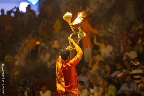 Ganga aarti, Portrait of young priest performing holy river ganges evening aarti at assi ghat in traditional dress with hindu rituals.
