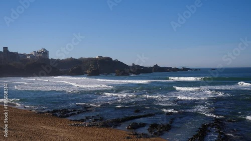 Beach with a mountain in the background. The beach is calm and the water is a light blue color, Biarritz, France