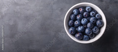 Fresh blueberries in a white bowl against a gray background Top view Soft focus. with copy space image. Place for adding text or design photo