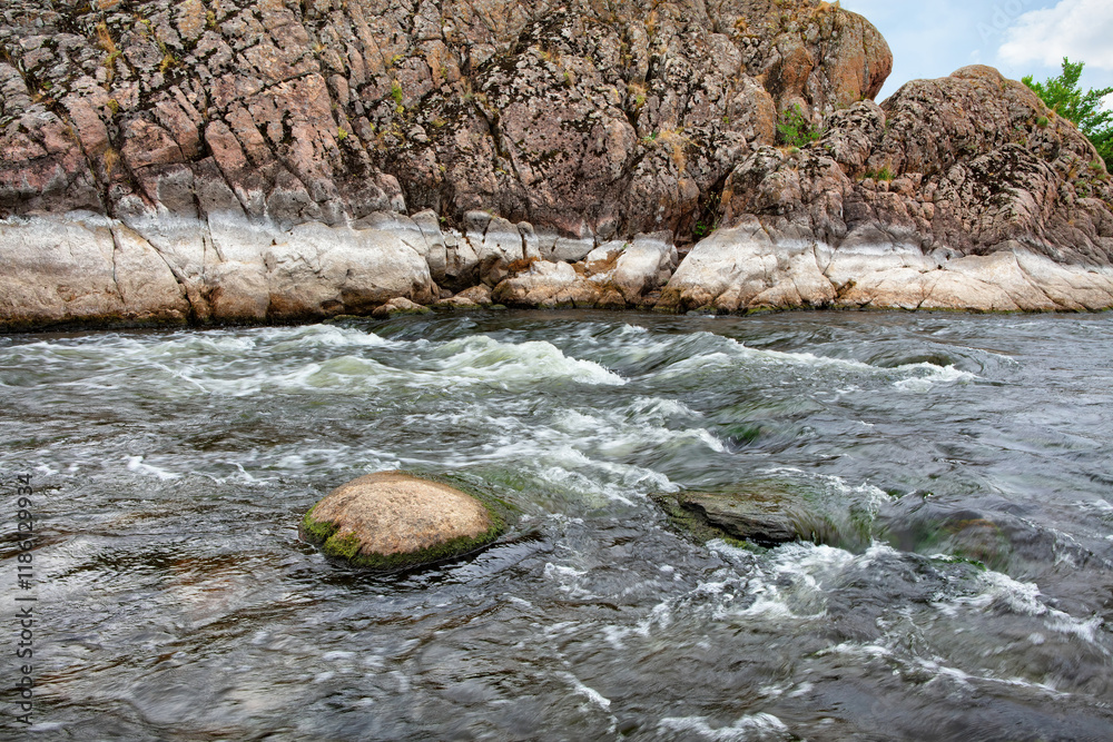Flowing river cascading between rocky cliffs in serene natural landscape