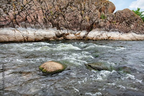 Obraz na płótnie Flowing river cascading between rocky cliffs in serene natural landscape w salonie