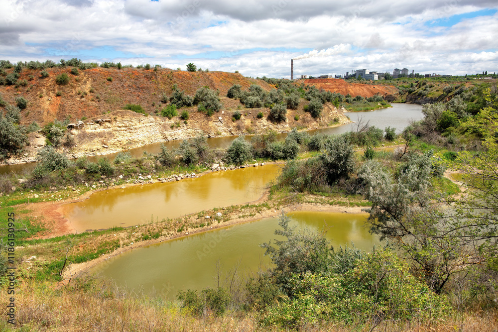 Lush riverbanks with rich vegetation under dramatic cloud patterns by the water's edge
