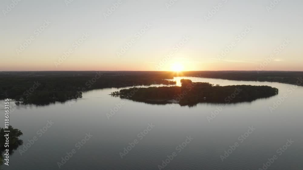Aerial view of Balsam Lake, Wisconsin, highlighting a tranquil sunset with scenic tree-lined islands. Aerial view of Balsam Lake, Wisconsin, highlighting a tranquil sunset with scenic tree-lined islands.