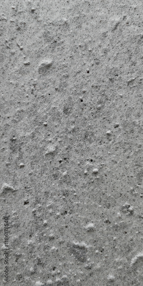 Close-up view of a textured concrete surface with various small imperfections. Close-up view of a textured concrete surface with various small imperfections.