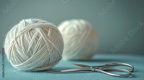 Soft white yarn balls and scissors on a light blue surface during a crafting ...