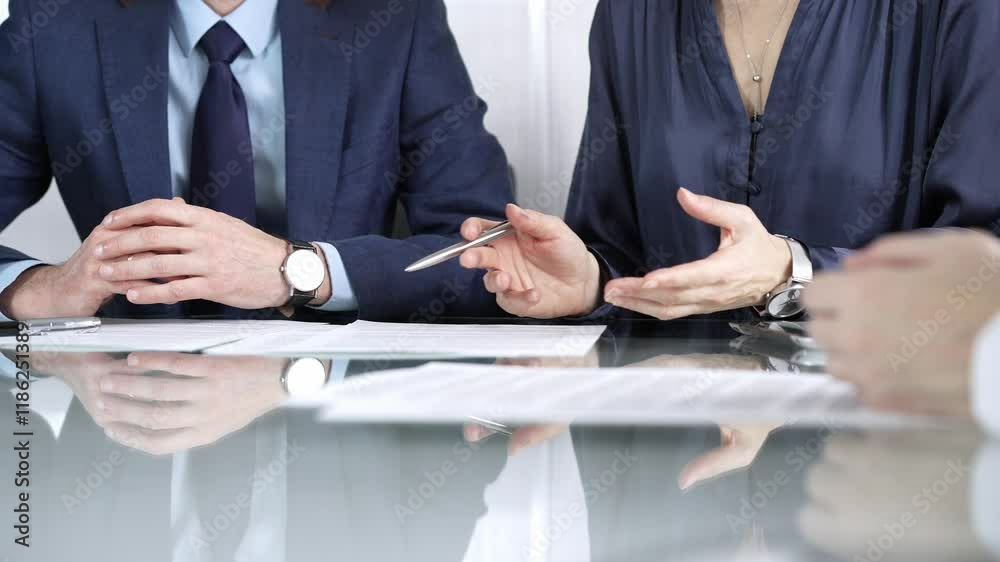 Business partners or lawyers are discussing contract papers during a meeting, negotiating and making decisions together. Business people concept, close up