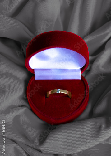 gold ring in a red velvet case in the shape of a heart photo