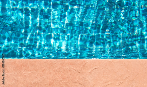 Water texture background,Pool edge with water wave pattern with sunlight reflection on floor for product in summer background,Top view swimming pool with blue water and brown floor brown floor photo