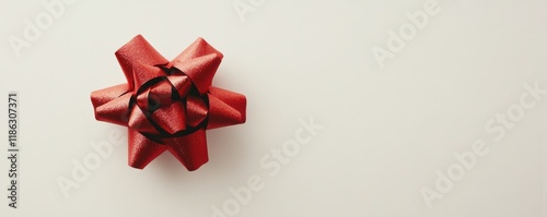 Elegant red gift bow on a plain white surface, minimal festive packaging, holiday sophistication.