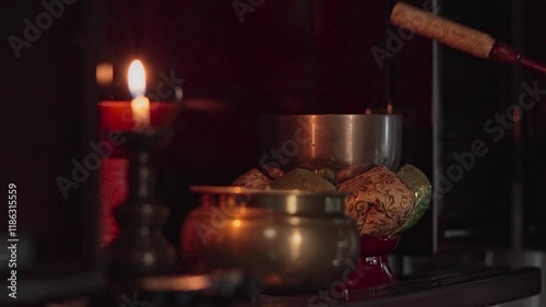 ロウソクが照らす仏壇のおりんを鳴らす